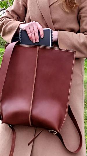 ruskea nahkarepuu naisen kädessä