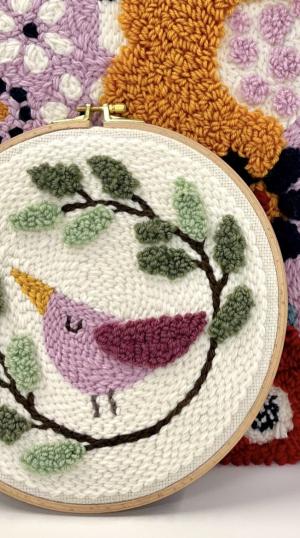 tuftattu lintutaulu pyöreään kehykseen