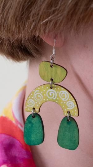 kelta-vihreä korvakoru roikkuu korvassa